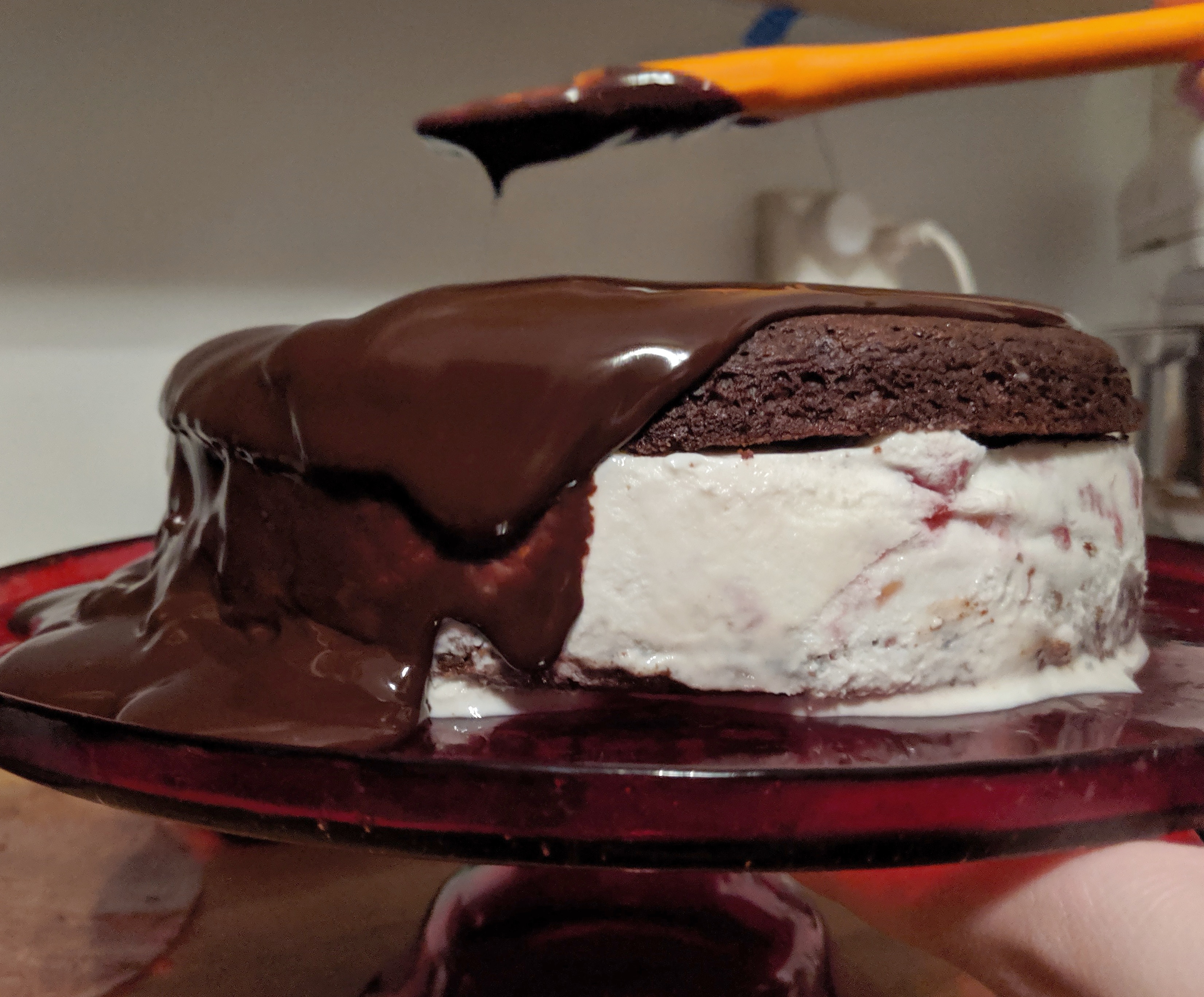 Chocolate ganache sliding over the edges of an ice cream cake