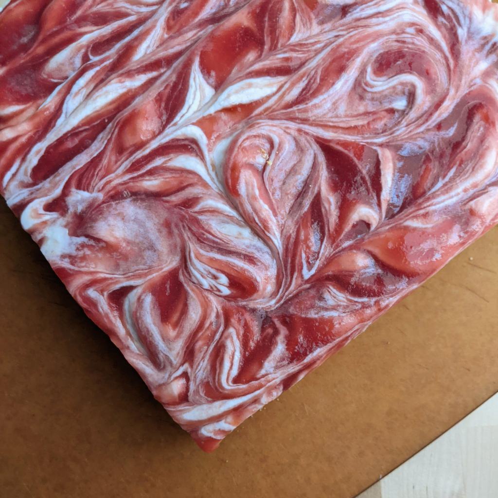 A whole cheesecake with rhubarb topping swirled beautifully through the top layer.